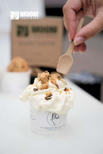 Cargar imagen en el visor de la galería, Main holding a biosourced sugarcane ice cream spoon over a creamy dessert in a cup.