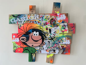 Pop art tableau featuring Gaston Lagaffe with vibrant colors, textures, and playful expressions on palette wood.